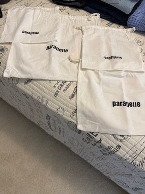 Parallelle set of 4 cotton drawstring bags.